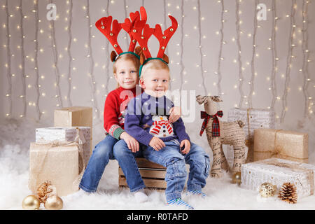 Portrait of white Caucasian heureux enfants frère et soeur portant des cornes de cerf célébrer Noël. Peu cute adorable garçon et fille dans la fratrie Banque D'Images