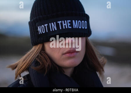 Girl wearing a black cap couvrant ses yeux avec le dit pas dans l'humeur Banque D'Images