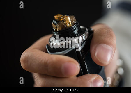 Vaping mod mech électroniques modernes de pièces de rechange de l'appareil sur fond noir. Banque D'Images