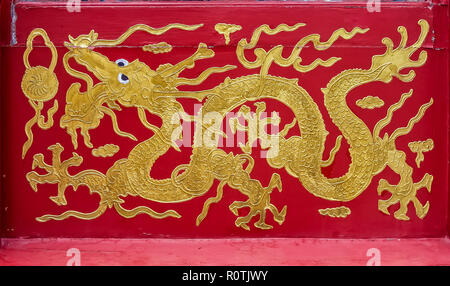 Chinise ouvragée motif dragon en peinture or sur fond rouge, Chine Banque D'Images