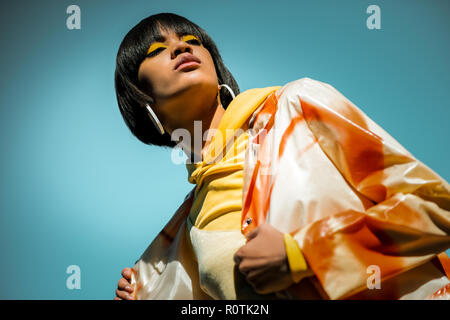 Rare short-haired woman wearing poncho orange vif Banque D'Images