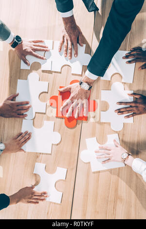 Vue supérieure de l'assemblage d'affaires multiraciale puzzle sur la table Banque D'Images