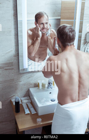 Bel homme avec un joli corps de muscle de son visage après la prise de douche Banque D'Images