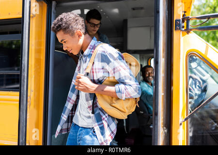 African American Student walking out of school bus driver tout en le regardant Banque D'Images