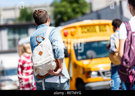 Vue arrière du groupe d'étudiants adolescents avec des sacs à dos à l'école à pied bus après l'école Banque D'Images