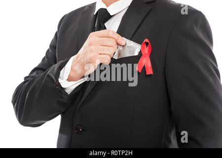 Cropped shot of woman in suit avec ruban rouge de sensibilisation au sida holding condom isolated on white Banque D'Images