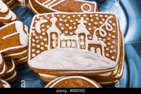 Close-up of a sweet Christmas gingerbread. L'église peinte. Beau détail de délicieuses pâtisseries aromatiques empilés sur une assiette. Décoré par glaçage blanc. Banque D'Images