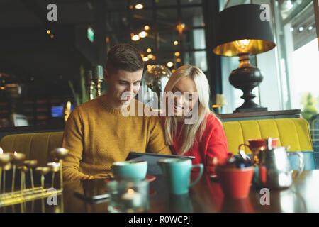 Couple de discuter sur la carte menu in cafe Banque D'Images