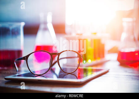 Verres sur écran de tablette avec des équipements scientifiques floue sur l'arrière-plan. L'éducation, technologie concept. Banque D'Images