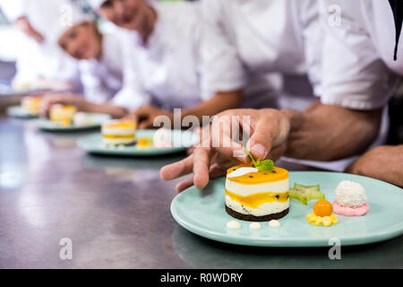 Chef de garnir dessert sur assiette Banque D'Images