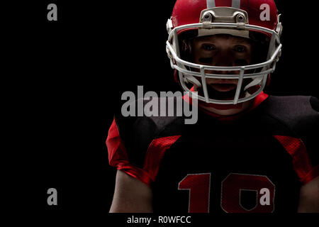 Joueur de football américain debout avec casque de rugby Banque D'Images