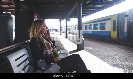 Pregnant Woman talking on mobile phone à la gare Banque D'Images