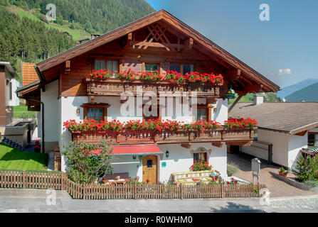 Les boîtes à fleurs à fleurs sur un balcon sur une maison typique à Neustift im Stubaital, Tyrol, Autriche Banque D'Images