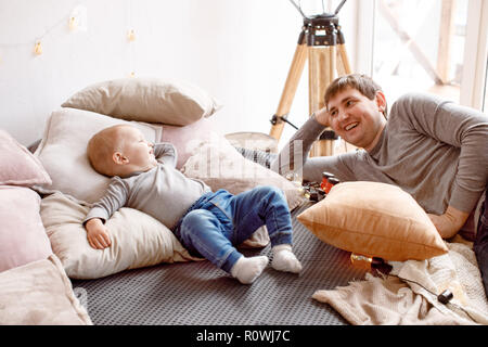 Father and baby lying on bed Banque D'Images