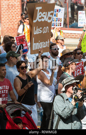 Une femme tient un panneau disant 'Jésus était un immigrant' à une contestation du droit de l'immigration et de mars le 30 juin 2018 à Atlanta, GA. Banque D'Images