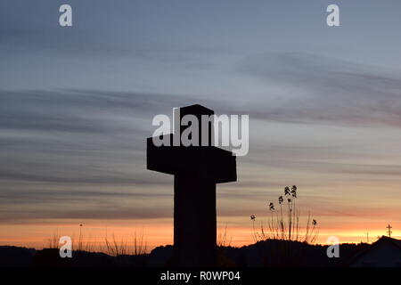 Chronologie de la soirée ciel crépuscule vu de derrière une croix en pierre de sable sculpture au cours de la coucher du soleil soleil dans le cimetière civil Reimsbach, Centre, Banque D'Images