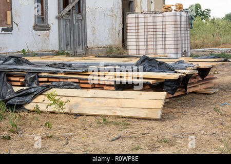 Une pile de planches de pin imprégné d'une solution antiseptique est séché à la construction site. Les matériaux de construction pour la construction d'une maison à ossature de bois. Banque D'Images