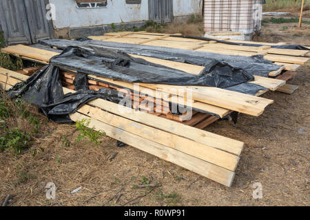 Une pile de planches de pin imprégné d'une solution antiseptique est séché à la construction site. Les matériaux de construction pour la construction d'une maison à ossature de bois. Banque D'Images