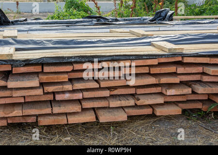 Une pile de planches de pin imprégné d'une solution antiseptique est séché à la construction site. Les matériaux de construction pour la construction d'une maison à ossature de bois. Banque D'Images