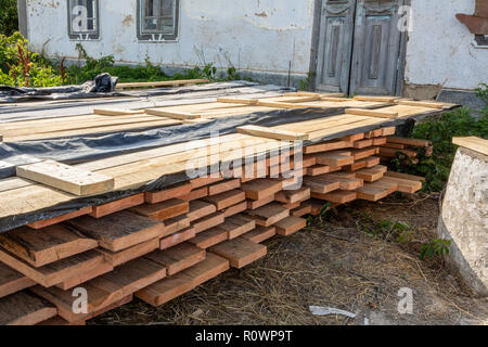 Une pile de planches de pin imprégné d'une solution antiseptique est séché à la construction site. Les matériaux de construction pour la construction d'une maison à ossature de bois. Banque D'Images