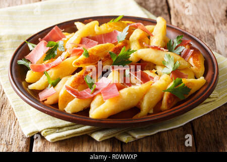 Schupfnudeln - un accompagnement traditionnel allemand. Ces nouilles de pommes de terre sont reconnaissables à leur forme inhabituelle, servi avec du lard et persil close-up o Banque D'Images