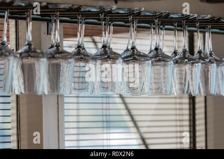 Une ligne de verres à vin accrocher la tête en bas dans le bar. Banque D'Images
