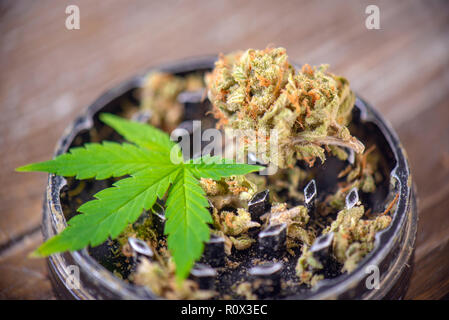Ppe et de cannabis grinder sur fond de bois, concept de la marijuana médicale Banque D'Images