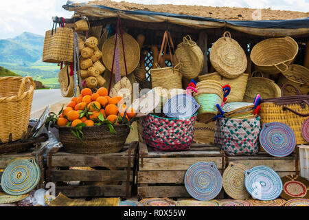 Chapeaux en osier artisanat, les oranges et autres souvenirs du marché au Maroc Banque D'Images