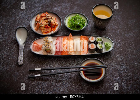 Assortiment d'aliments asiatiques. Différents rouleaux de sushi placés sur des assiettes en céramique Banque D'Images