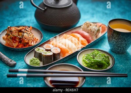 Assortiment d'aliments asiatiques. Différents rouleaux de sushi placés sur des assiettes en céramique Banque D'Images