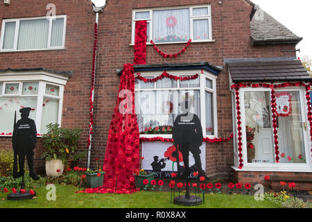 Une maison dans Station Road, Aldridge en Walsall qui s'est tranformé en route de pavot comme près de 100 maisons ont été décorées avec 24 000 coquelicots rouges et silhouette des statues de soldats à l'honneur des gens qui ont vécu et ont perdu la vie dans la Première Guerre mondiale. Banque D'Images