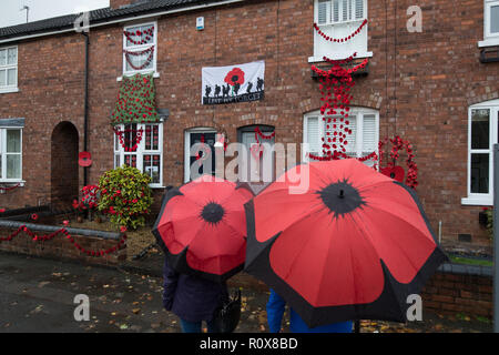 Les gens regardent une maison dans Station Road, Aldridge en Walsall qui s'est tranformé en route de pavot comme près de 100 maisons ont été décorées avec 24 000 coquelicots rouges et silhouette des statues de soldats à l'honneur des gens qui ont vécu et ont perdu la vie dans la Première Guerre mondiale. Banque D'Images