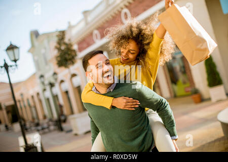 Portrait de jeune homme jeune femme détient sur son dos , s'amuser et go to shopping Banque D'Images