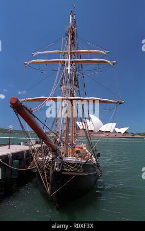 Un petit trois-mâts barque-goélette 'Southern Swan', amarrée le long de Campbells Cove avec l'Opéra de Sydney dans l'arrière-plan Banque D'Images