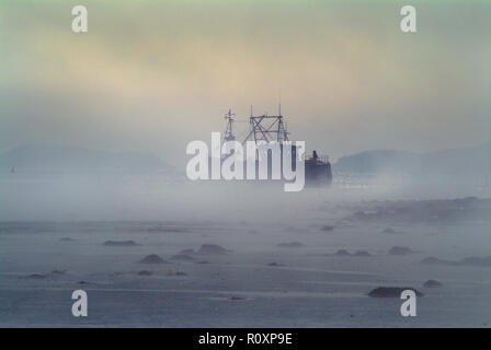 Un bateau de pêche aux pétoncles navigue sur le chenal jusqu'au port de Kirkcudbrifght dans un épais brouillard. La marée est basse et le canal est étroit et peu profond Banque D'Images