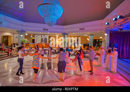 Les invités rejoignent des artistes folkloriques marocains lors d'une soirée marocaine organisée à l'hôtel TUI Suneo Kenzi Europa à Agadir, Souss-Massa, Maroc. Banque D'Images