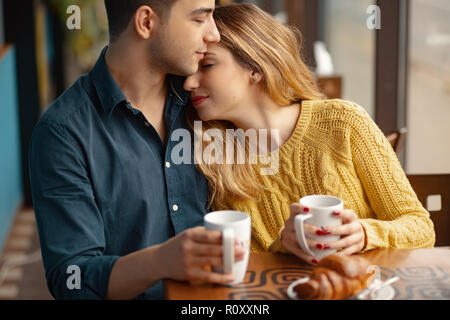 Jeune beau couple sur date dans un coffee shop. Dans l'amour l'homme et la femme assis dans un café, boire du café Banque D'Images