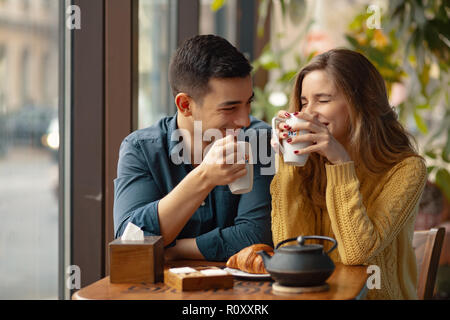 Jeune beau couple sur date dans un coffee shop. Dans l'amour l'homme et la femme assis dans un café, boire du café Banque D'Images