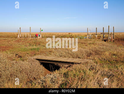 Une petite passerelle en bois sur un chemin dans les marais salants près du quai dans le port de North Norfolk à Thornham, Norfolk, Angleterre, Royaume-Uni, Europe. Banque D'Images