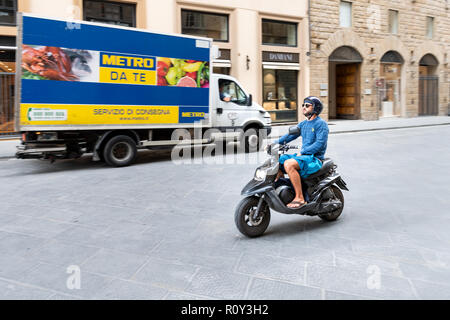 Florence, Italie - 31 août 2018 : panoramique de jeunes Italiens man riding, driving, déménagement sur vespa scooter, moto sur la rue de FIRENZE, Italia Banque D'Images