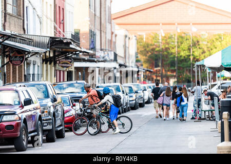 New Orleans, USA - 22 Avril 2018 : vieille ville Decatur Street en Louisiane célèbre cité, les gens sur les bicyclettes, les magasins boutiques dans coucher soleil soir Banque D'Images