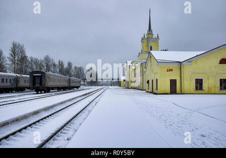 La station de plate-forme et Dno en hiver en soirée. Le nom de la station est écrit sur l'immeuble de la peinture rouge en russe 'non'. L'oblast de Pskov, Russie Banque D'Images