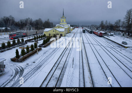 La station de plate-forme et Dno en hiver en soirée. Le nom de la station est écrit sur l'immeuble de la peinture rouge en russe 'non'. L'oblast de Pskov, Russie Banque D'Images