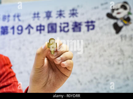 Shanghai, Chine. Nov 8, 2018. Un bénévole présente un badge pour commémorer la Journée des journalistes au centre des médias de la première importation de Chine Expo (CIEE) à Shanghai, la Chine orientale, 8 novembre 2018. Diverses activités ont eu lieu pour saluer le 19e jour des journalistes. Credit : Shen Bohan/Xinhua/Alamy Live News Banque D'Images