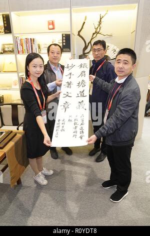 Shanghai, Chine. Nov 8, 2018. Yan Weiqi (1re L), journaliste de Guangming Daily, présente ses travaux de calligraphie au centre des médias de la première importation de Chine Expo (CIEE) à Shanghai, la Chine orientale, 8 novembre 2018. Diverses activités ont eu lieu pour saluer le 19e jour des journalistes. Credit : Shen Bohan/Xinhua/Alamy Live News Banque D'Images