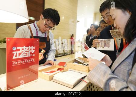 Shanghai, Chine. Nov 8, 2018. Un membre du personnel stamps post card pour les journalistes au centre des médias de la première importation de Chine Expo (CIEE) à Shanghai, la Chine orientale, 8 novembre 2018. Diverses activités ont eu lieu pour saluer le 19e jour des journalistes. Credit : Shen Bohan/Xinhua/Alamy Live News Banque D'Images
