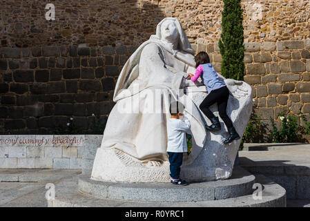 Enfants jouant au monument à Santa Teresa de Jesus, à côté de la Puerta del Alcázar. Avila, Castille et Leon, Espagne, Europe Banque D'Images