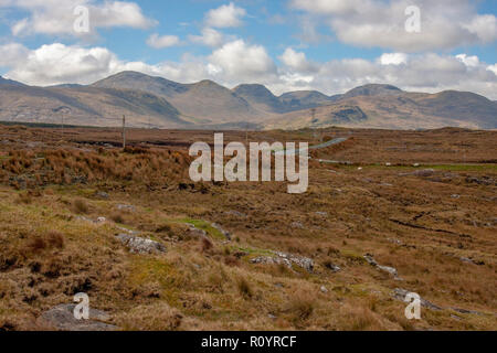 Le trafic d'un bog road, en face de l'Irlande avec les montagnes du comté de Galway Connemra en arrière-plan. N59 Leenane à Clifden avec tourbières tourbe adjacent. Banque D'Images