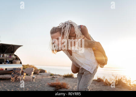 Jeune femme avec des dreadlocks hugging her strong bel homme serré Banque D'Images