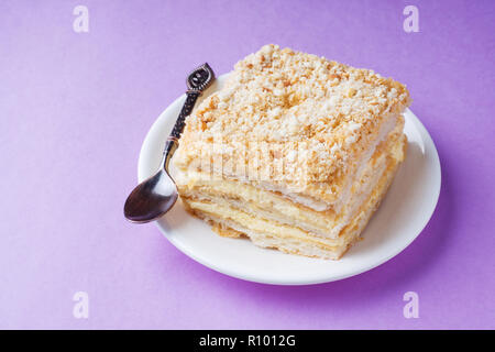 Gâteau feuilletée avec crème vanille Millefeuille Napoléon tranche couleur sur fond violet Banque D'Images